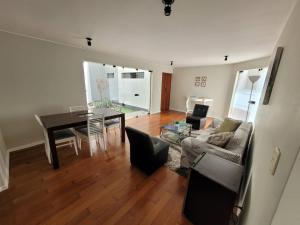 a living room with a couch and a table at Espacio Luxury Apartments- Edificio Alcanfores in Lima