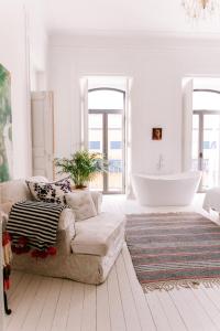 ein Wohnzimmer mit einem Sofa und einer Badewanne in der Unterkunft Casa Melchior in Portimão