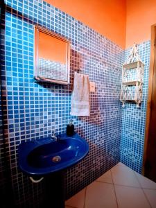 Baño de azulejos azules con lavabo azul en Hospedaria do Tom, en Lençóis