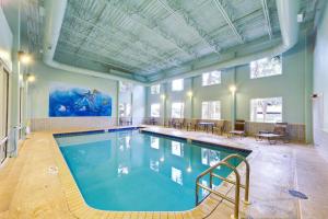 a large swimming pool in a room with tables and chairs at Tidewater 2308 by Emerald Coast Retreats in Panama City Beach