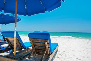 two chairs and an umbrella on a beach at Tidewater 2308 by Emerald Coast Retreats in Panama City Beach