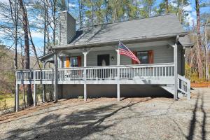 ein Haus mit einer Veranda mit amerikanischer Flagge in der Unterkunft Firefly Lodge - Cozy 4 bedroom cabin minutes to Helen in Sautee Nacoochee