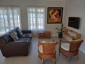a living room with a couch and two chairs at Rees Cottage in Yzerfontein