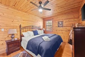 Schlafzimmer mit einem Bett und einem Deckenventilator in der Unterkunft Firefly Lodge - Cozy 4 bedroom cabin minutes to Helen in Sautee Nacoochee