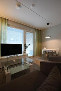 a living room with a large flat screen tv at Hieno yksiö Tapiolan urheilupuistossa. in Espoo