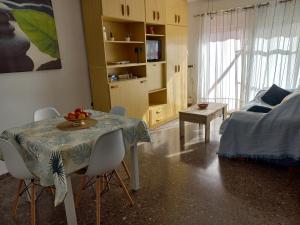 een woonkamer met een tafel en stoelen en een bed bij Appartement proche mer in Santiago de la Ribera