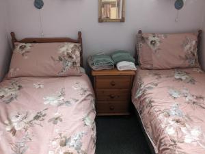 two beds sitting next to each other in a bedroom at Rosecare Barn in Bude