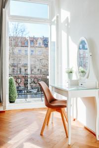 uma secretária e uma cadeira num quarto com uma janela em namastay! Eleganz mit Blick auf dem Wasserturm em Mannheim