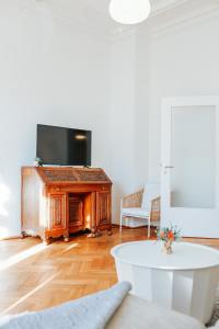 uma sala de estar com uma televisão e uma mesa em namastay! Eleganz mit Blick auf dem Wasserturm em Mannheim