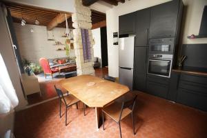 uma cozinha com uma mesa de madeira e cadeiras num quarto em Appartement de caractére, proche palais des papes em Avignon