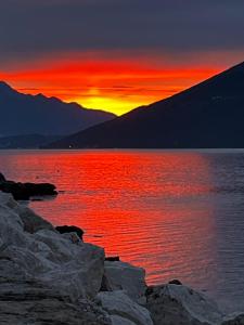 a sunset over a body of water with rocks at Apartments Bane in Herceg-Novi