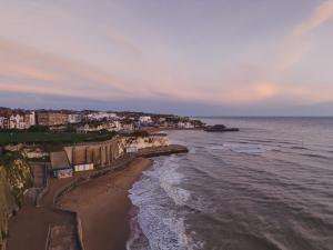 eine Luftblick auf den Strand bei Sonnenuntergang in der Unterkunft Buckingham Mews _ Rockpool Cottage 5 in Kent