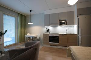 a kitchen and living room with a couch and a table at Hieno yksiö Tapiolan urheilupuistossa. in Espoo