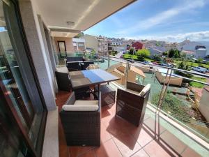 d'un balcon avec une table et des chaises et une vue. dans l'établissement Apartment with direct access to the beach(WIFI), à Sanxenxo