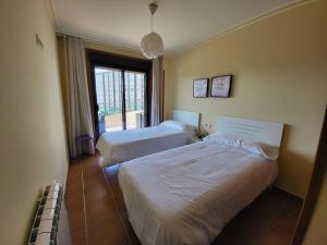 Cette chambre comprend 2 lits et une fenêtre. dans l'établissement Apartment with direct access to the beach(WIFI), à Sanxenxo