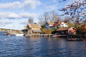 eine Gruppe von Häusern auf einem Dock auf einem Wasserkörper in der Unterkunft Blå Huset in Vaxholm