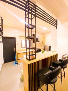 a kitchen with a bar with black stools at Service apartment is Abuja in Abuja