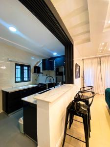 a kitchen with a large counter and chairs in a room at Service apartment is Abuja in Abuja