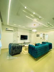 a living room with a blue couch and a tv at Service apartment is Abuja in Abuja