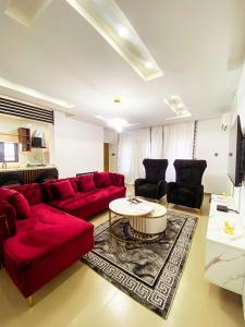 a living room with a red couch and a table at Service apartment is Abuja in Abuja