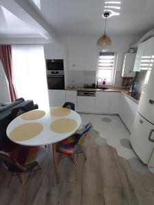 a kitchen with a table and chairs in a room at Mosnita Apartament in Moşniţa Nouă