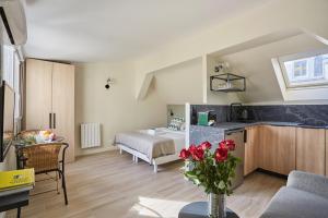 eine Küche und ein Wohnzimmer mit einer Blumenvase in der Unterkunft Residence Center of Paris by Studio prestige in Paris