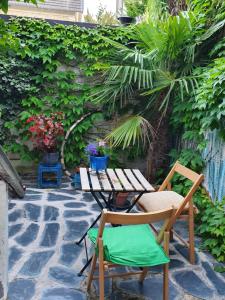een patio met een tafel en stoelen op een stenen vloer bij DOUX COCON DE 50 m2 PARIS-LE RAINCY in Le Raincy