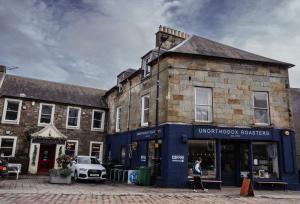 una mujer está parada frente a un edificio en The Kinross Residence, en Kinross