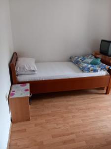 a small bedroom with a bed and a table at HOTEL WIEN in Barakovići