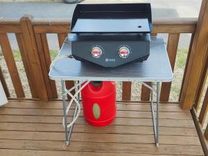 a grill sitting on a table with a red bucket at Mobil-home in Valras-Plage