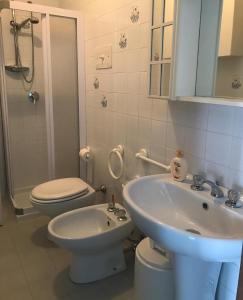 een badkamer met een witte wastafel en een toilet bij La Maison du Port - Apartment with Pool in Manerba del Garda