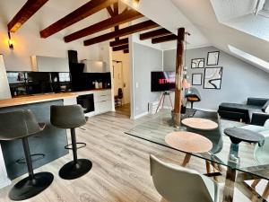 a living room with a glass table and chairs at Stilvoll im Zentrum Balken Loft in Bochum