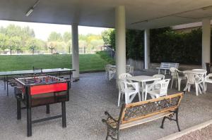 een patio met tafeltennistafels en stoelen bij La Maison du Port - Apartment with Pool in Manerba del Garda