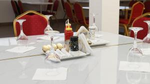 einen weißen Tisch mit Weingläsern und Keksen darauf in der Unterkunft Equine Hotel in Ruiru