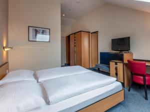 um quarto de hotel com uma cama e uma televisão em B&B HOTEL Eschweiler em Eschweiler
