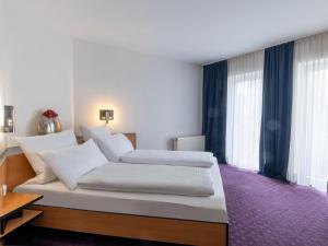 um quarto com 2 camas e um tapete roxo em B&B HOTEL Eschweiler em Eschweiler