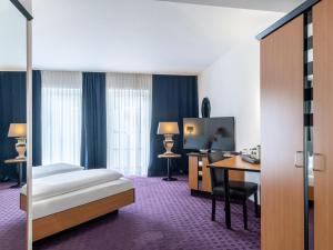 エシュヴァイラーにあるB&B HOTEL Eschweilerのベッドとデスクが備わるホテルルームです。