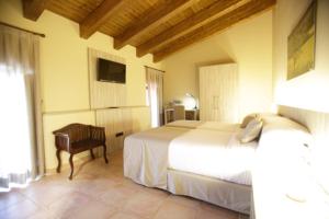 a bedroom with two beds and a desk and a television at Hotel Can Panyella in Gélida