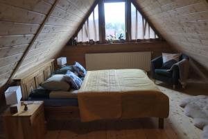 コシチェリスコにあるApartament Panorama Tatryのベッドルーム1室(ベッド1台、屋根裏部屋の椅子付)