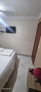 um quarto branco com uma cama e uma mesa em Pousada do Farol Bar e Restaurante em Vila Velha