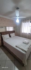 Schlafzimmer mit einem großen weißen Bett und einer Decke in der Unterkunft Pousada do Farol Bar e Restaurante in Vila Velha