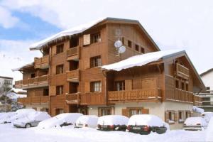 a large building with cars parked in the snow at Alpina Lodge - 02 - Appart rdc duplex - 8 pers in Les Deux Alpes