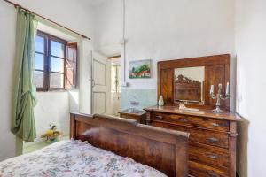 a bedroom with a wooden dresser and a mirror at La Casa Della Lavanda in Castelvecchio di Rocca Barbena