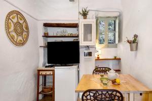 a small kitchen with a table and a television at La Casa Della Lavanda in Castelvecchio di Rocca Barbena