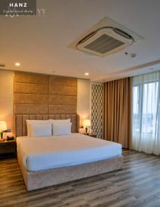 a bedroom with a large bed and a large window at HANZ Premium Mai Vy Hotel in Tây Ninh