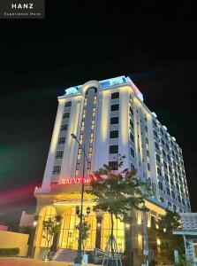 a large white building with lights on it at night at HANZ Premium Mai Vy Hotel in Tây Ninh