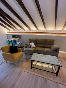 un soggiorno con divano e tavolino da caffè di Precioso ático a Santander