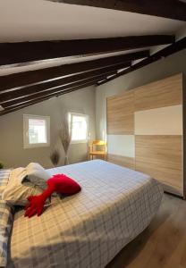 una camera da letto con un letto con un oggetto rosso sopra di Precioso ático a Santander