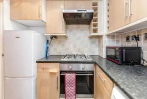 a kitchen with a stove and a microwave at APlaceToStay Central London Apartment, Zone 1 BOND in London