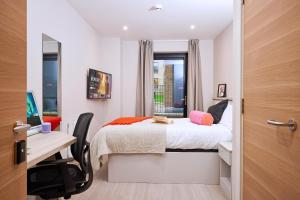 1 dormitorio con cama, escritorio y ventana en ALTIDO Aparthotel at Vita Iona Street - Adults only en Edimburgo